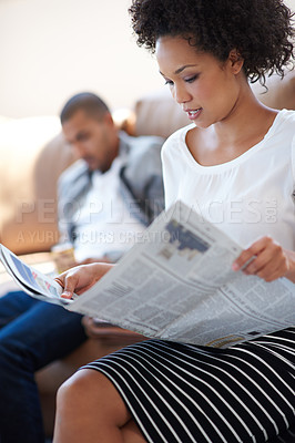 Buy stock photo Woman, reading and newspaper story on sofa for article, information or knowledge on global events in living room. Print, update and person with man for publication, newsletter or classifieds in home