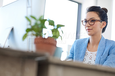 Buy stock photo Low angle view of a young creative woman working at her desk pc