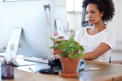 Buy stock photo Beautiful african businesswoman working on her pc at her desk in a bright office space