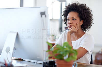 Buy stock photo Beautiful creative professional looking intently at her pc in a bright open plan office space