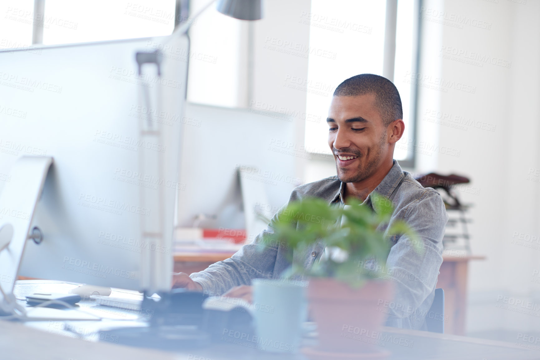 Buy stock photo Young multi-ethnic man at work in a bright office space