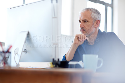Buy stock photo Low angle view of a mature professional man looking intently at his pc