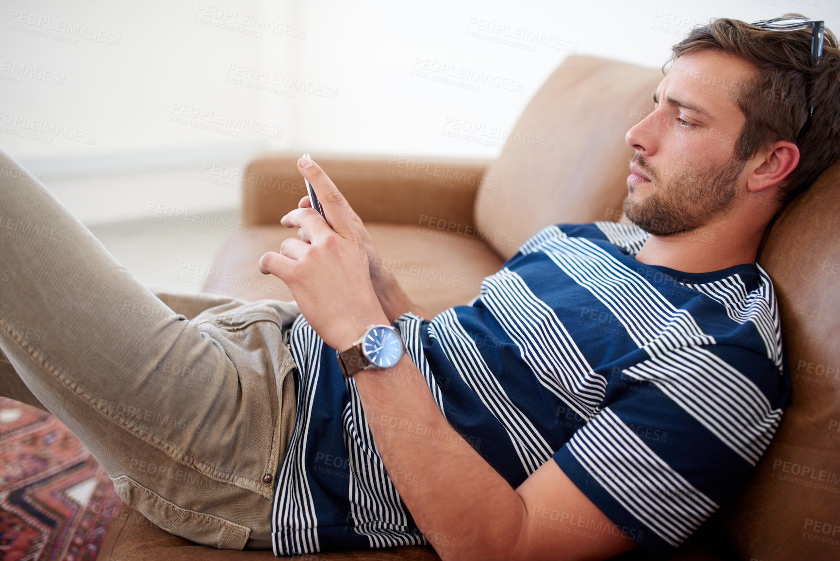 Buy stock photo Home, serious and man with smartphone for reading, breakup text and rejection on dating website. Male person, cellphone or mobile app on sofa in living room, chatting and typing on social media