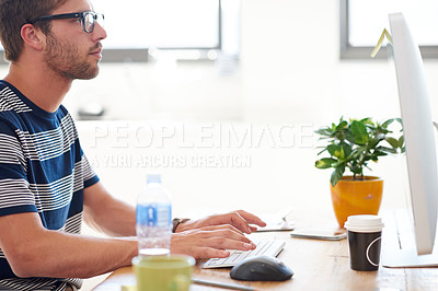 Buy stock photo Cropped profile image of a young professional working at his pc in a bright office space