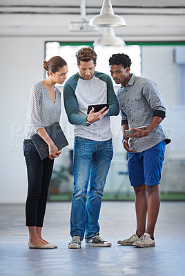 Buy stock photo Full length shot of three creative professionals checking something on a digital tablet