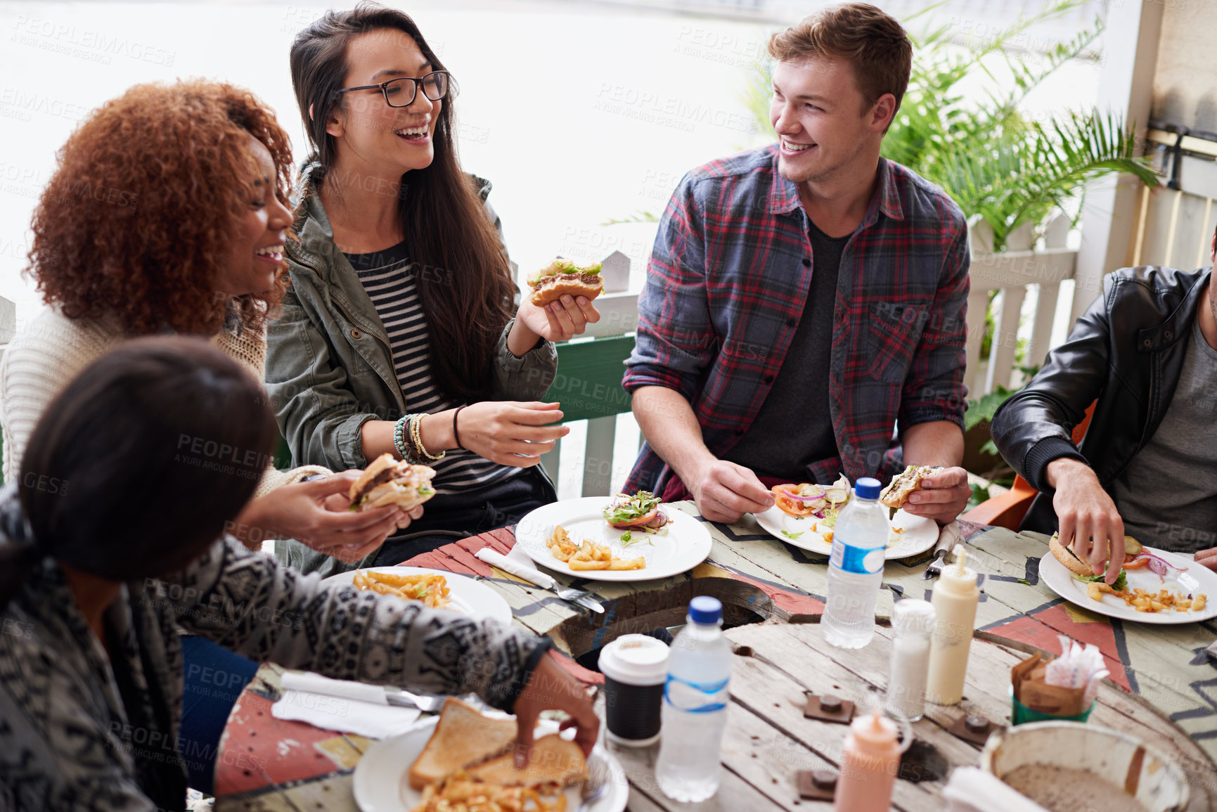 Buy stock photo Cropped shot of a friends eating burgers outdoors