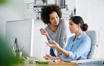 Buy stock photo Cropped shot of two casually dressed businesswoman looking at something on a computer screen