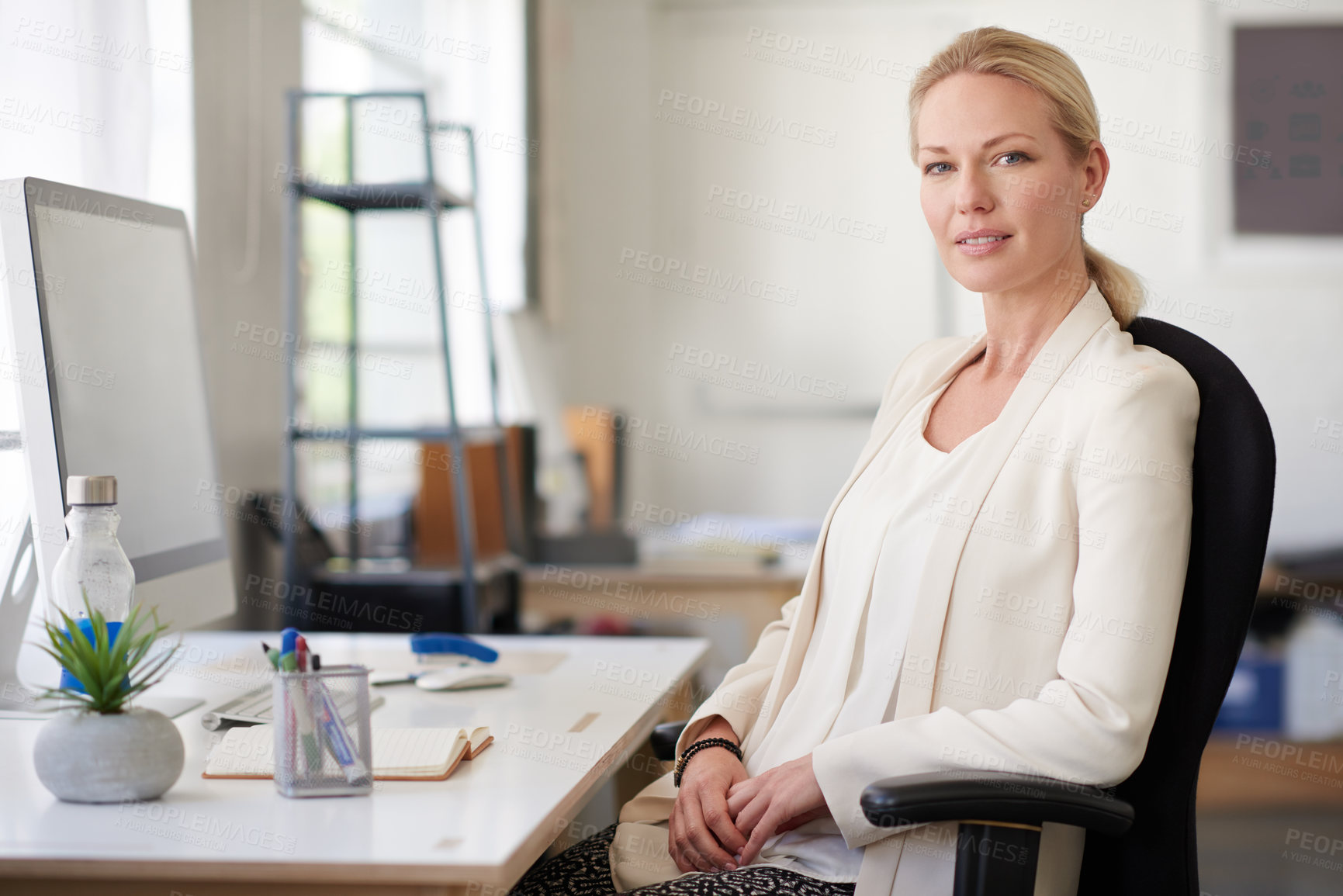 Buy stock photo Relaxed businesswoman looking positively at the camera in her bright office space