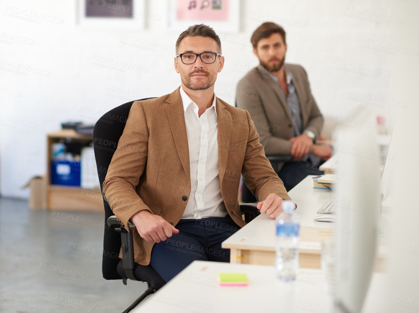 Buy stock photo Businessman, glasses and portrait on desk, serious and coworking of colleagues, computer and together. Face, working and entrepreneur in company, journalist and confidence in startup and creative