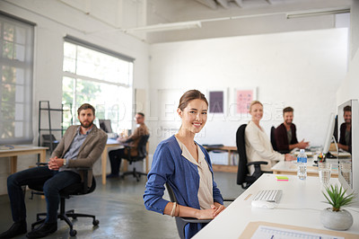 Buy stock photo Wide angle shot of creative professionals smiling at the camera in a bright open office space