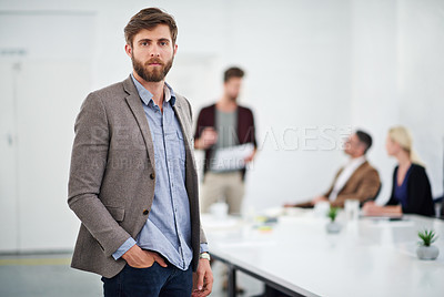 Buy stock photo Portrait of a young businessperson in a conference room with colleagues in the background