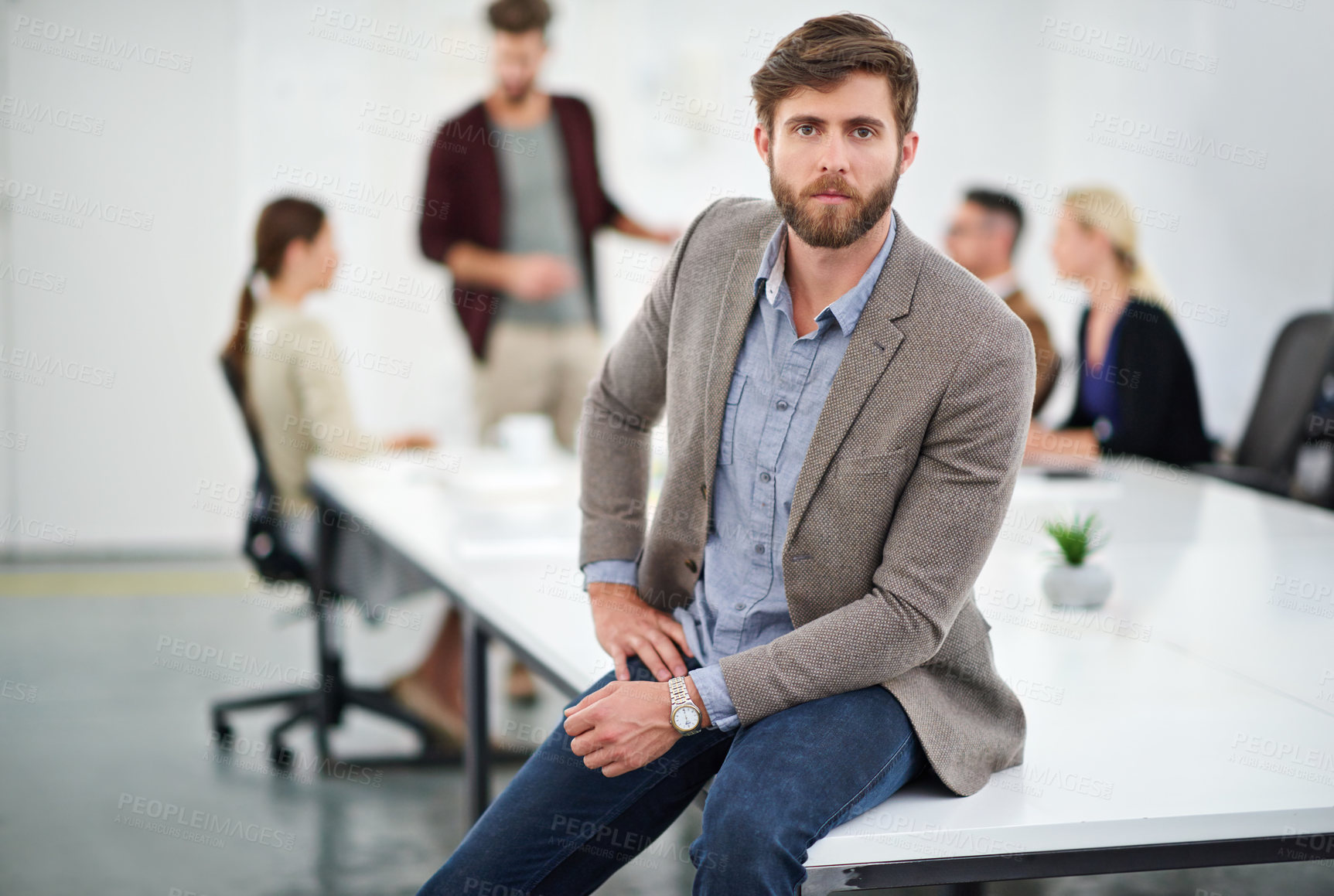 Buy stock photo Portrait of a young businessperson in a conference room with colleagues in the background