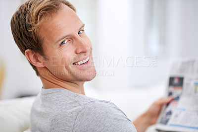 Buy stock photo Portrait of a handsome man reading a newspaper at home