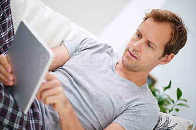 Buy stock photo Man, tablet and morning reading in home for web ebook or internet connection, connectivity or research. Male person, technology and online news on apartment sofa or article review, relax or lounge