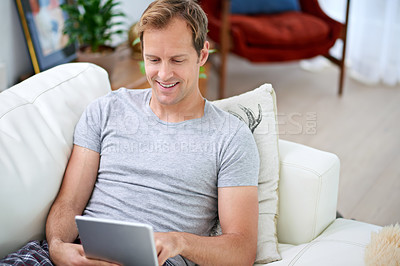 Buy stock photo Man, tablet and relax in living room for social media, networking and communication on vacation. Technology, reading and happy on couch for work from home, email and ceo of online global company