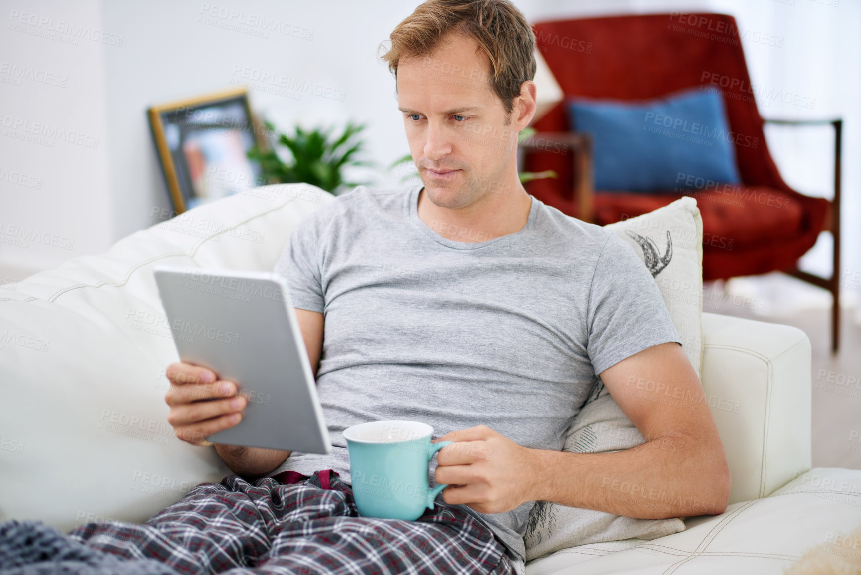Buy stock photo Tablet, man and coffee in apartment for social media, networking and communication on vacation. Technology, reading and pride on couch for online company, work from home and ceo in living room