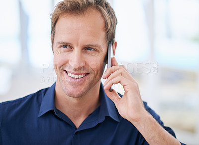 Buy stock photo Shot of a handsome man using his cellphone at home
