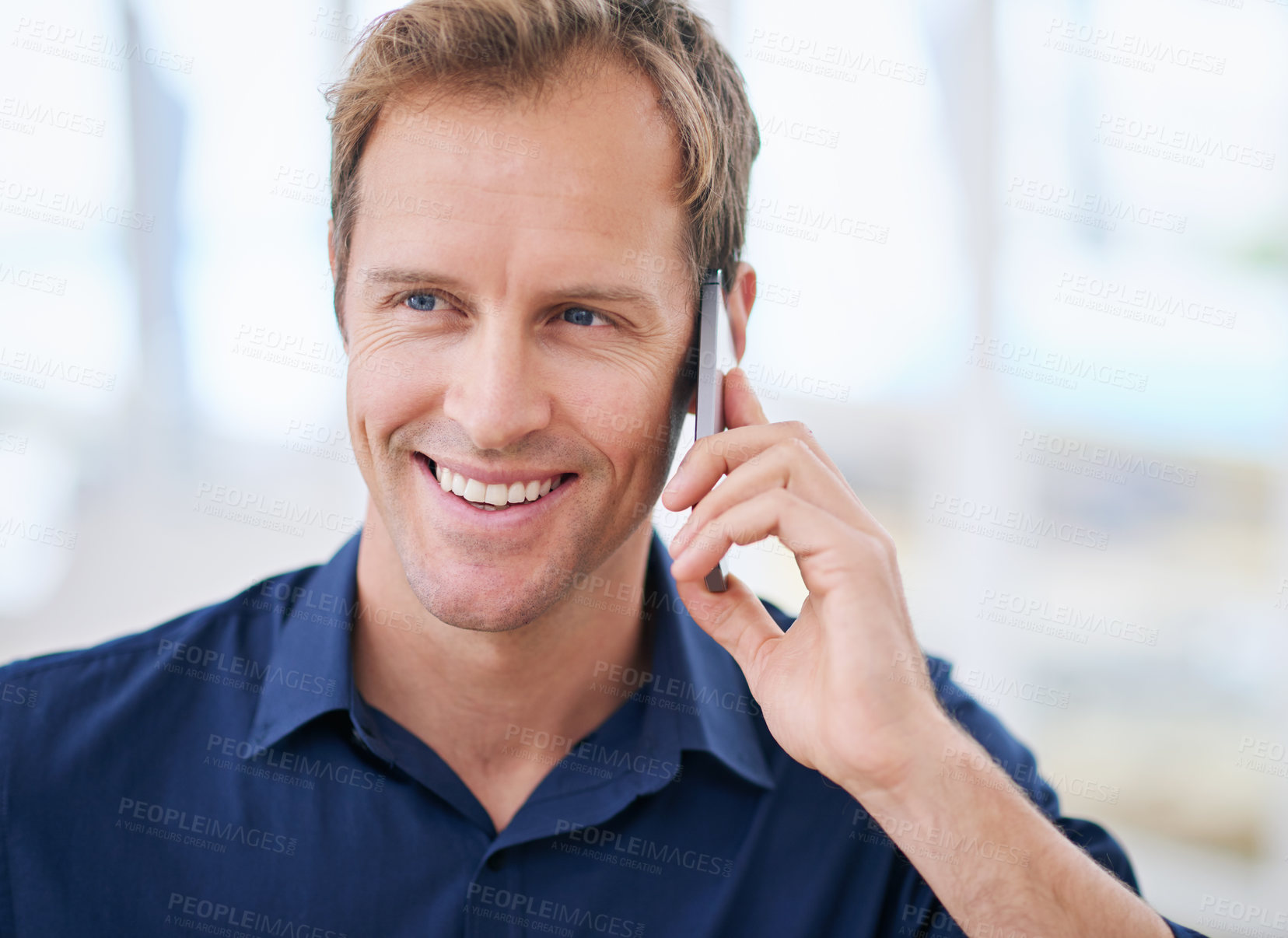 Buy stock photo Shot of a handsome man using his cellphone at home