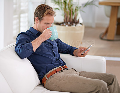 Buy stock photo Shot of a handsome man having coffee while texting