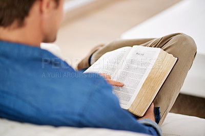Buy stock photo Cropped shot of a man reading the Bible at home