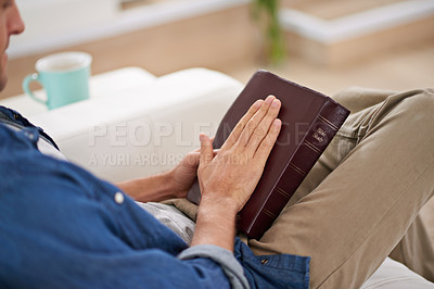 Buy stock photo Cropped shot of a man reading the Bible at home