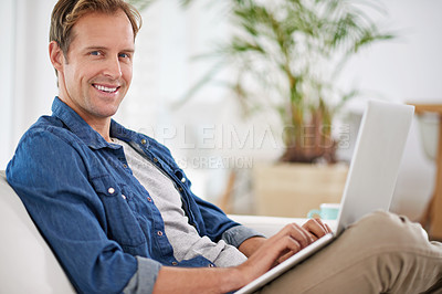 Buy stock photo Portrait of a handsome man using his laptop at home