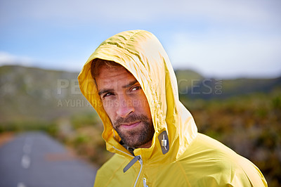 Buy stock photo Portrait of a handsome man in running rain gear with a road behind him