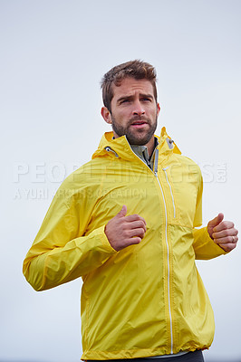 Buy stock photo Low angle shot of a handsome young man running in rainy weather