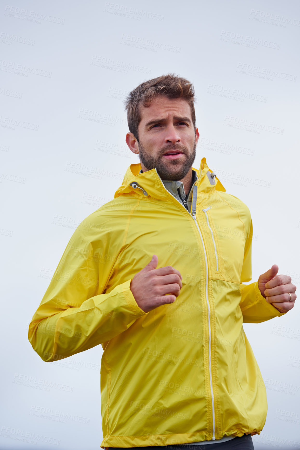 Buy stock photo Low angle shot of a handsome young man running in rainy weather