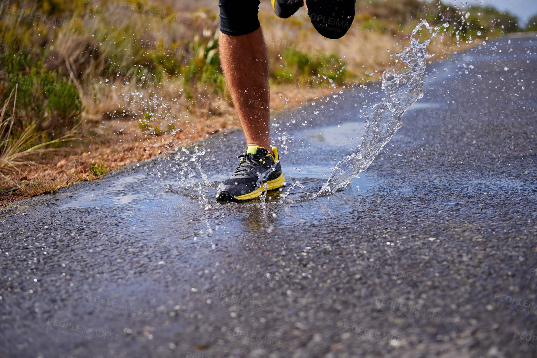 Buy stock photo Cropped shot of a young man running on a country road