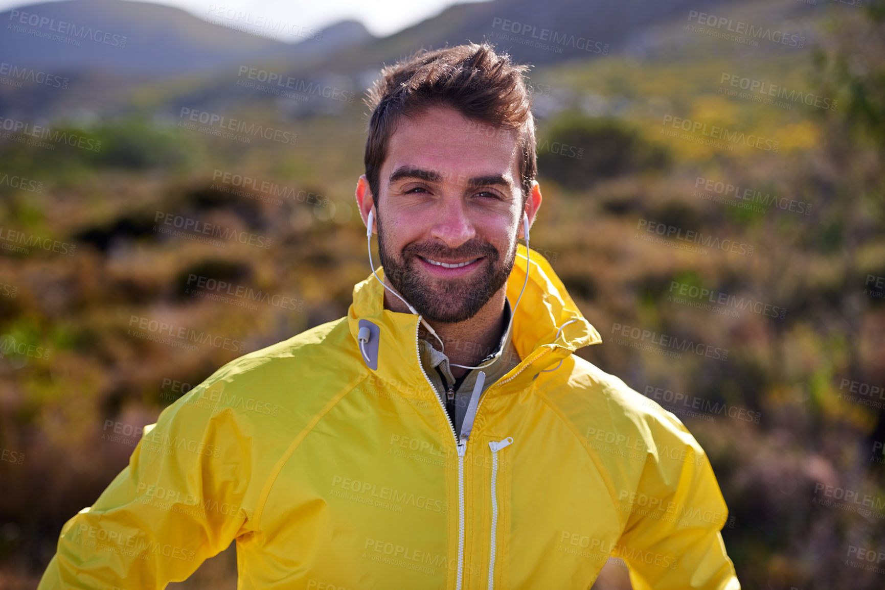 Buy stock photo Shot of a handsome young man in all weather gear posing in front of natural bush