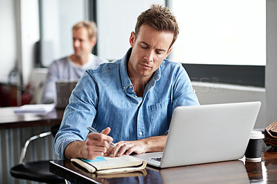 Buy stock photo Man, writing on notebook and laptop in office for information with planning design, email and internet research. Male programmer, coding language and studying on computer for software development job