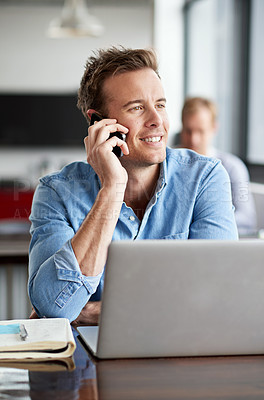 Buy stock photo Shot of a man talking on his cellphone in a casual work environment 