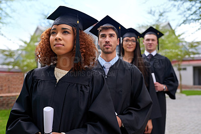 Buy stock photo Shot of graduating university students standing in a row looking up