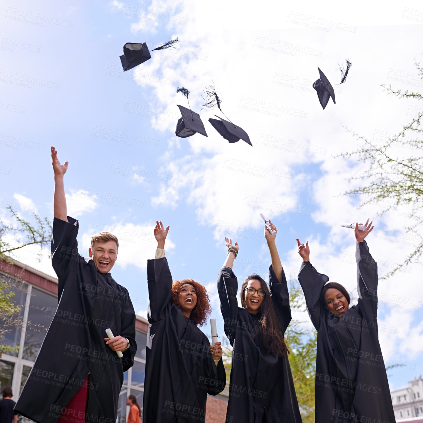 Buy stock photo Low angle shot of student throwing their graduation hats into the air