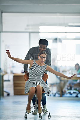 Buy stock photo Employees, fun and pushing chair in office with game for company culture, celebrate and team building. Man, woman and riding sitting on seat in workplace for support, funny and work competition
