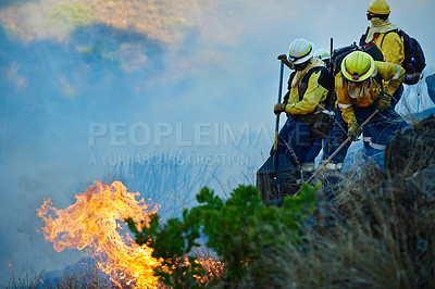 Buy stock photo Shot of fire fighters combating a wild fire