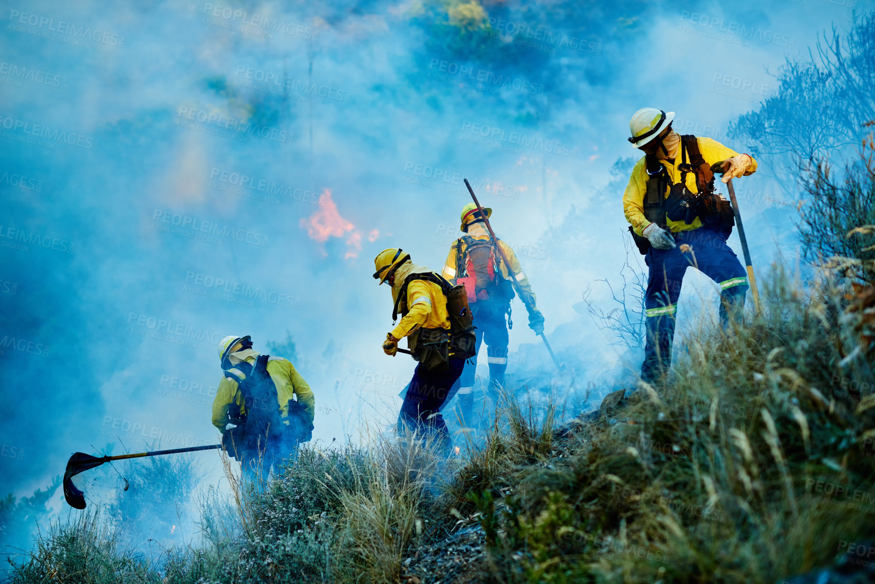 Buy stock photo Shot of fire fighters combating a wild fire