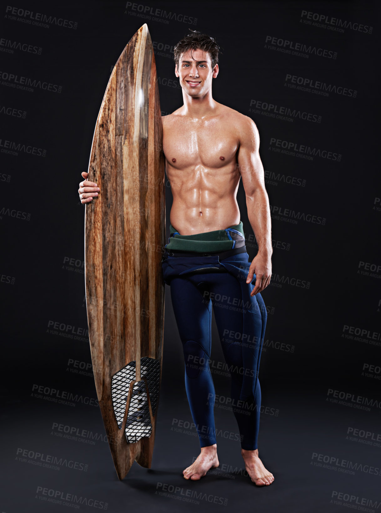 Buy stock photo Surfboard, athlete and male surfer in studio, wetsuit and portrait isolated on background. Body, smile and swimsuit for water sports for man model person, equipment and wooden for fitness or hobby