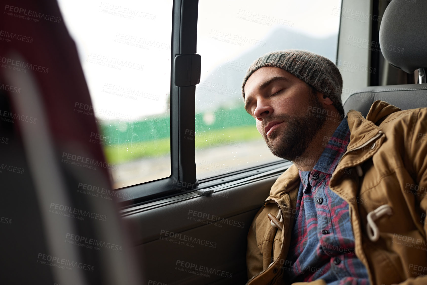 Buy stock photo Shot of a handsome asleep in the back seat of a travelling vehicle