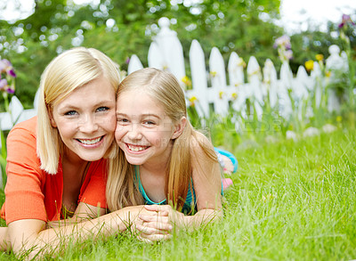 Buy stock photo Cute little girl lying on the grass outdoors with her mom