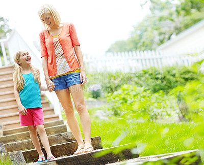 Buy stock photo Happy little girl standing outdoors and smiling with her mother