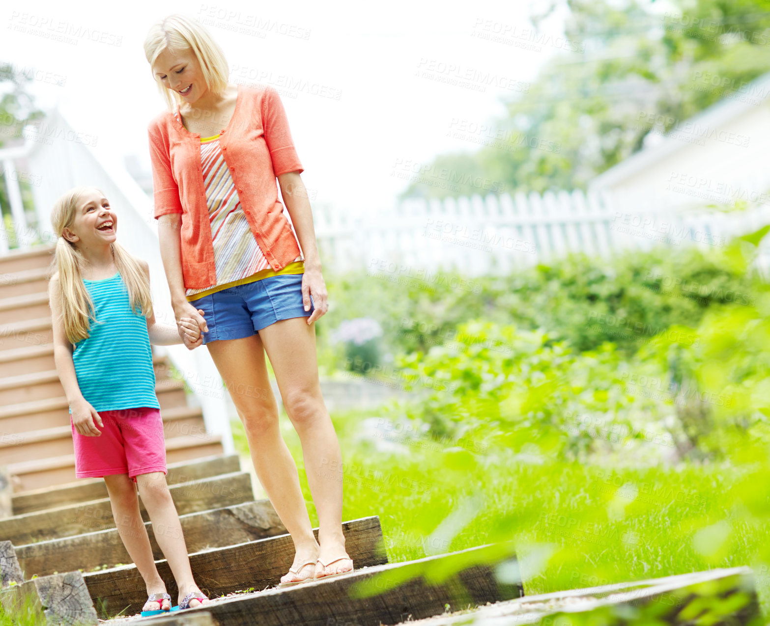 Buy stock photo Happy little girl standing outdoors and smiling with her mother