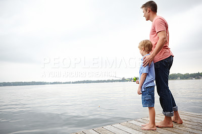 Buy stock photo A father teaching his son how to fish with copyspace