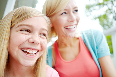 Buy stock photo A mother and daughter sitting together and looking away happily