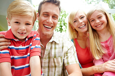 Buy stock photo A family of four sitting together and smiling