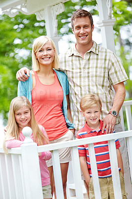 Buy stock photo A family of four standing together on their porch