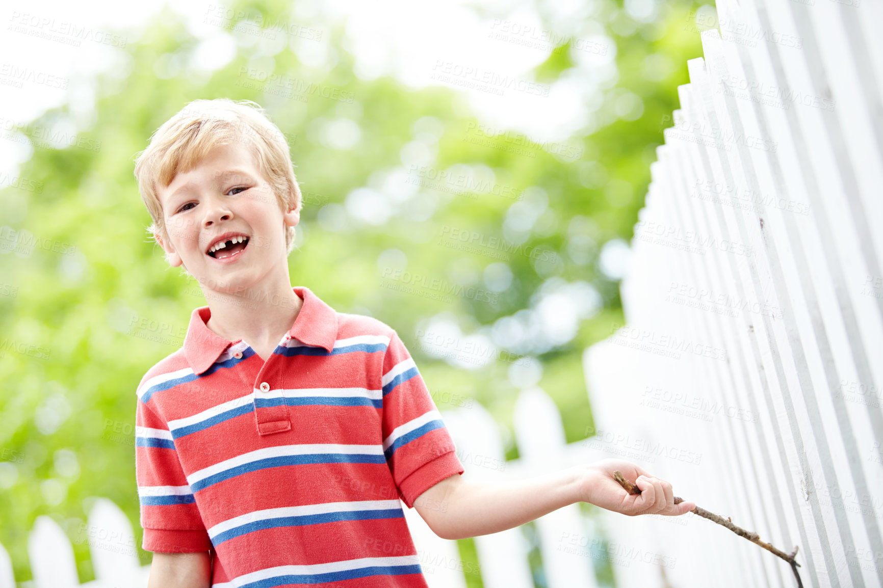 Buy stock photo Smile, portrait and playful with kid and picket fence for fun, break and summer vacation. Happiness, explore and childhood development with young boy in backyard of home for holiday and outdoors