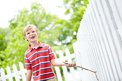 Buy stock photo Smile, stick and playful with kid and picket fence for fun, break and summer vacation. Happiness, explore and childhood development with young boy in backyard of home for holiday and outdoors