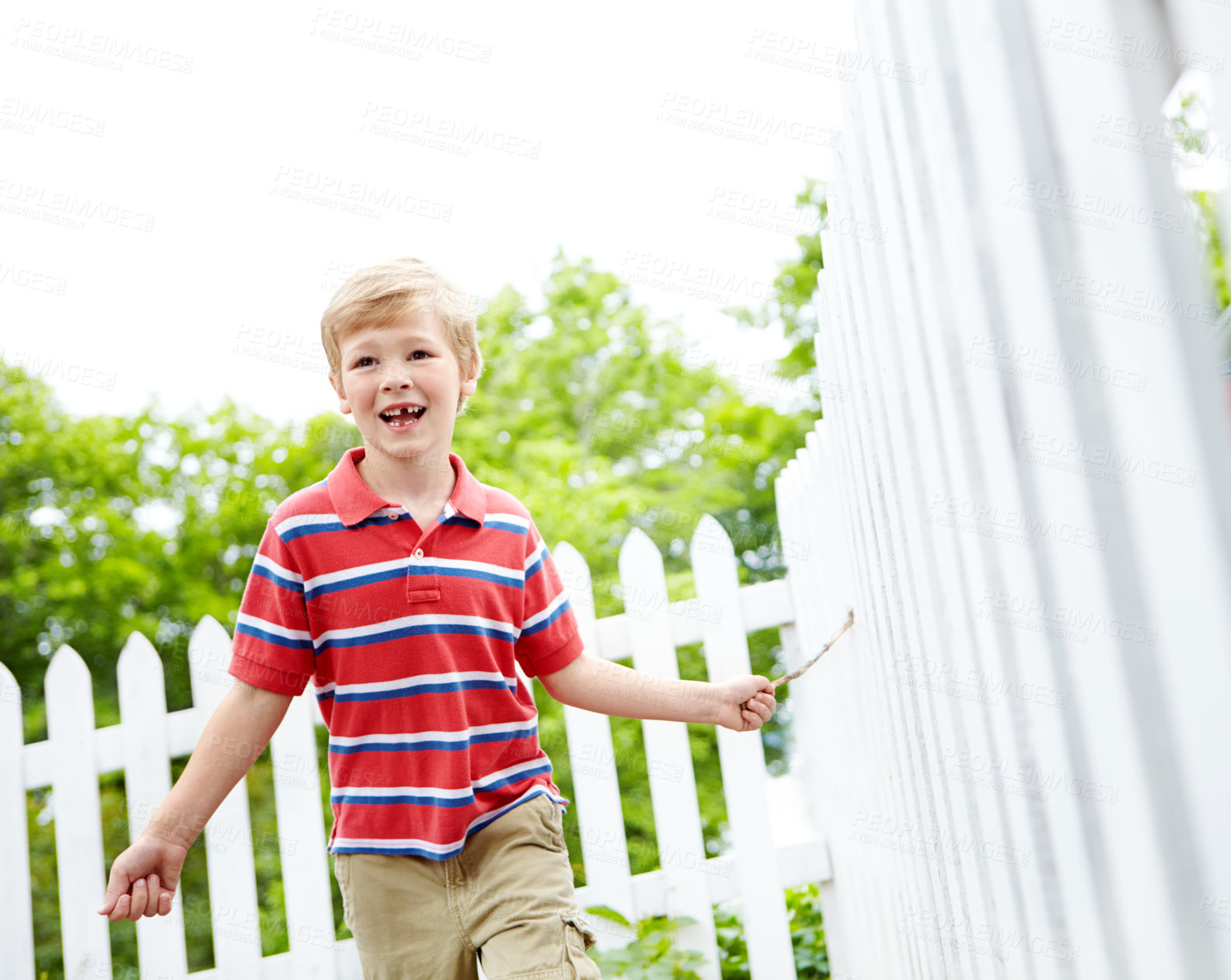 Buy stock photo Stick, running and playful with kid and picket fence for fun, break and summer vacation. Happiness, explore and childhood development with young boy in backyard of home for holiday and outdoors